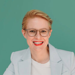 Habportrait von Dr Nina Herbort vor einem grünen Hintergrund.